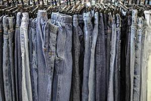 fila di pantaloni jeans blu impiccati in negozio