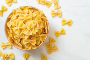 pasta secca di farfalle crude in una ciotola foto