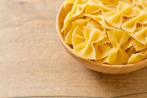 pasta secca di farfalle crude in una ciotola foto