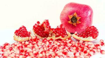 totale e parte di un' Melograno frutta con Melograno semi su bianca sfondo foto