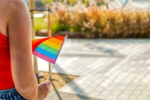 donna mano hold piccolo il arcobaleno orgoglio bandiera. foto