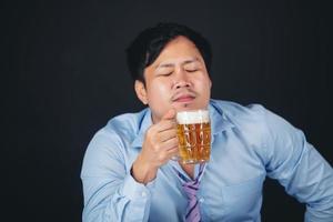 ritagliato primo piano di un uomo che beve birra a casa foto