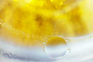 oro olio bolle vicino su. cerchi di acqua macro. astratto brillante giallo e blu sfondo foto