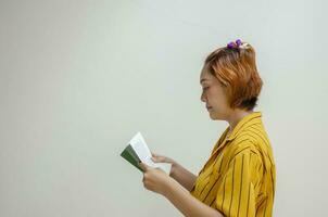 giovane donna in posa in piedi e lettura un' libro isolato su bianca sfondo foto