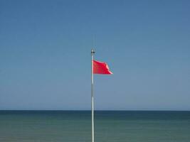 rosso bandiera a mare foto