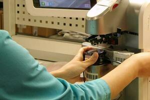 fabbrica per fabbricazione spettacolo lenti a contatto e cornici, miopia occhiali, occhiali da sole, produzione linea. avvicinamento di tecnico produzione lente. mani di un' maestro nel ottica salone e riparazione negozio foto