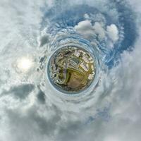 minuscolo pianeta nel cielo con nuvole prospiciente vecchio cittadina, urbano sviluppo, storico edifici e incrocio stradale. trasformazione di sferico 360 panorama nel astratto aereo Visualizza. foto