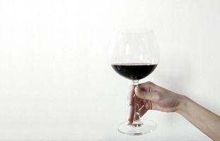 mano di donna con bicchiere di vino su sfondo bianco
