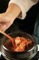 cucinando kimchi stufato la minestra o kimchi jigae foto