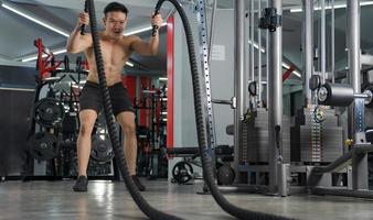 uomo che si allena con le corde da battaglia in palestra allenamento funzionale allenamento fitness sportivo