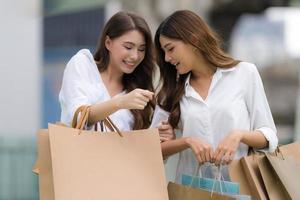 amici felici che fanno shopping due giovani donne tengono in mano le borse della spesa foto