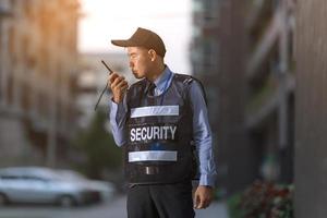uomo della sicurezza in piedi all'aperto usando la radio portatile foto