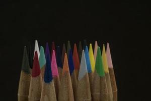 matite colorate affilate su uno sfondo nero spazio copia foto