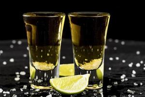 due bicchieri di tequila con lime e sale foto