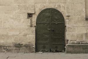 una vecchia porta nel muro del pulsante del campanello della città vecchia foto