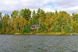 Casa su un' a distanza lago nel il autunno foto