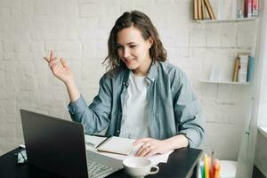 fiducioso donna d'affari coinvolgente nel video conferenza a partire dal ufficio, virtuale insegnamento e in linea comunicazione concetto. professionale donna utilizzando ragnatela telecamera per a distanza incontri e in linea formazione scolastica foto