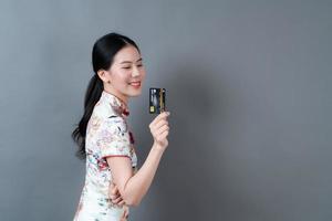 la donna asiatica indossa un abito tradizionale cinese con la carta di credito in mano foto