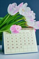 calendario e fiori vicino su foto