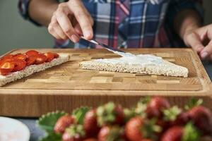 donna cucinando panini crostini con un' fresco frutti di bosco nel il cucina foto