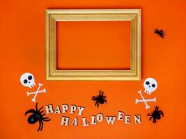 Halloween decorazioni su un arancia sfondo. chincaglieria, un' contento Halloween iscrizione e un' telaio con un' posto per testo foto