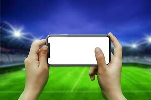 Telefono nel mani, orizzontale posizione. isolato schermo per modello. calcio stadio nel sfondo foto