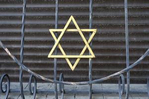 una staccionata di metallo con una stella ebraica dorata foto