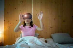 giovane donna che utilizza l'auricolare per realtà virtuale a letto. vr, tecnologia digitale futura, giochi, intrattenimento cinematografico, metaverse, nft e concetto di cyberspazio 3d foto