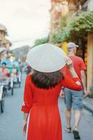 contento donna indossare ao dai vietnamita vestire, asiatico viaggiatore giro turistico a Hoi un antico cittadina nel centrale Vietnam. punto di riferimento e popolare per turista attrazioni. Vietnam e sud-est viaggio concetto foto