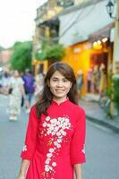 contento donna indossare ao dai vietnamita vestire, asiatico viaggiatore giro turistico a Hoi un antico cittadina nel centrale Vietnam. punto di riferimento e popolare per turista attrazioni. Vietnam e sud-est viaggio concetto foto