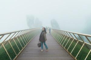 donna viaggiatore giro turistico d'oro ponte a il superiore di il ba n / A colline. punto di riferimento e popolare. Vietnam e sud-est Asia viaggio concetto foto