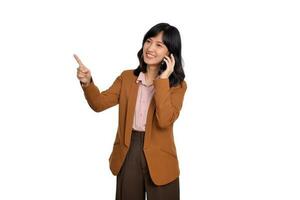 giovane attività commerciale asiatico donna ascoltando per mobile Telefono e puntamento dito per gratuito copia spazio isolato su bianca sfondo foto