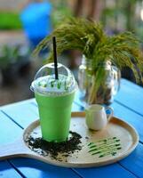 verde tè frappé nel un' bicchiere su di legno tavolo foto