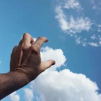 gesticolando con la mano nel cielo foto