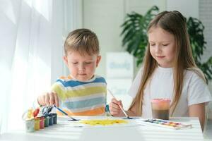fratello e sorella disegnare un' immagine con vernici su un' pezzo di carta. bambini siamo apprendimento per disegno. casa creatività. foto
