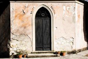 porta in metallo nero con cuore inciso e scritta religiosa foto