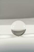 trasparente cristallo palla su un' bianca sfondo. foto