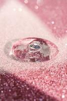 un' far cadere di cosmetico gel su un' rosa splendente sfondo. foto