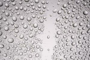 gocce di acqua su un' trasparente grigio sfondo. foto