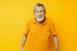 anziano dai capelli grigi uomo con un' grigio barba emozione gesti mani giallo sfondo foto
