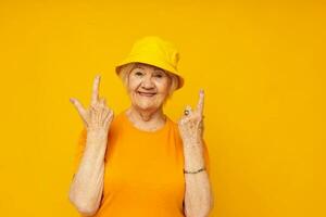 ritratto di un vecchio amichevole donna contento stile di vita nel un' giallo copricapo avvicinamento emozioni foto