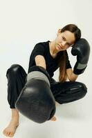 atletico donna boxe nero guanti in posa gli sport leggero sfondo foto