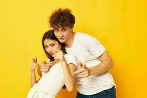 giovane ragazzo e ragazza in posa insieme nel bianca magliette amicizia giallo sfondo inalterato foto