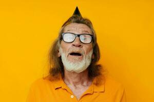 ritratto di contento anziano uomo divertimento compleanno berretto su il testa monocromatico tiro foto