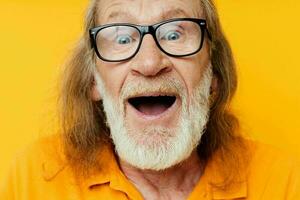 anziano dai capelli grigi uomo con bicchieri viso avvicinamento giallo sfondo foto