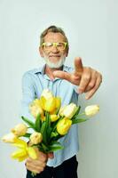 anziano uomo nel un' blu camicia con un' mazzo di fiori ritagliata Visualizza foto