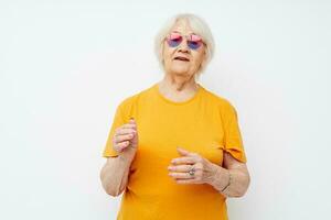 anziano donna nel un' giallo maglietta in posa avvicinamento emozioni foto
