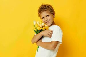 foto ritratto Riccio poco ragazzo nel un' bianca maglietta con un' mazzo di fiori studio stile di vita inalterato