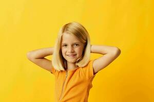 carino poco ragazza bionda dritto capelli in posa Sorridi divertimento giallo sfondo inalterato foto