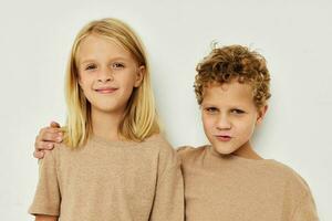 carino elegante bambini nel beige magliette in posa per divertimento infanzia inalterato foto